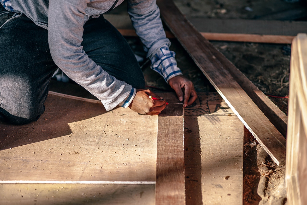 Worker Measuring Size Wood For Renovation